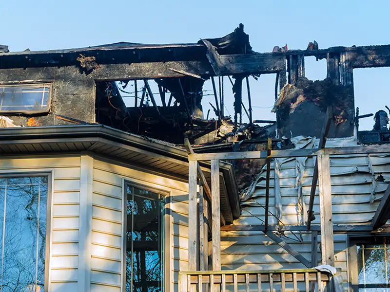 Partially burned house with extensive fire damage to the upper floor and roof.